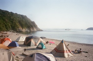 浜辺にテントを張って、キャンプをする写真