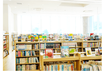 写真：図書館内 子ども向け開架棚に並ぶ本のイメージ